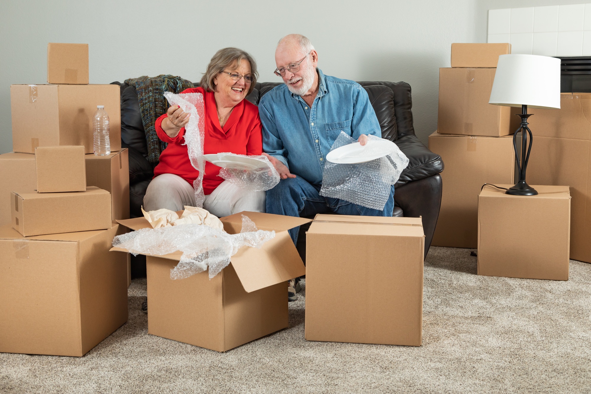 Senior Adult Couple Packing or Unpacking Moving Boxes. commercial storage